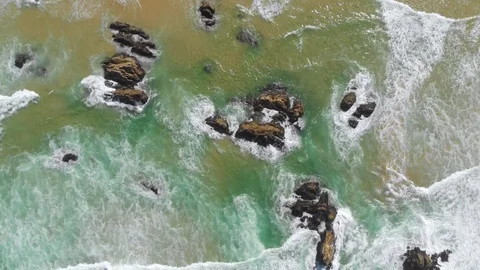 Aerial top down moving forward of ocean and beach with wave action and Stock Footage 111428384