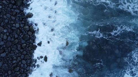 Aerial Top Down Ocean Waves Crashing on Rocky Black Beach – Drone Footage 4K 库存照片