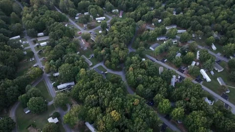 Aerial top down over mobile trailer homes on sunny summer day. Colorful trees Stock Footage 317133643