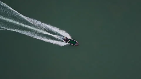 Aerial Top Down Overhead Motorboat with White Wake and Emerald Water Patterns Stock Footage 335181582