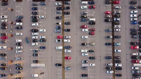 Aerial top-down of a packed parking lot, organized rows of vehicles casting Stock Footage 305527442