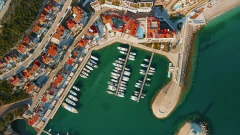 Aerial top down pan of Mediterranean marina and breakwater in Lustica Bay Stock Footage 327013554