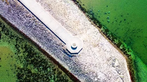 Aerial top-down pullback of stone harbor point in shallow ocean water Vídeos de archivo 333957846