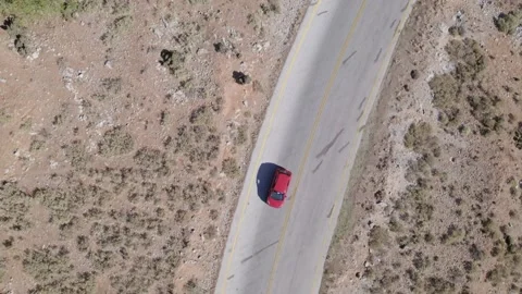 Aerial, top down of red car drives into a turn of a scenic switchback road cross Stock-Footage 168255233