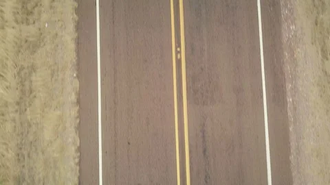 Aerial top down shot of empty two lane road in desert on cloudy day Stock Footage 118970422