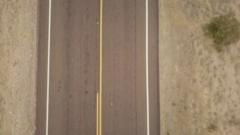 Aerial top down shot of empty two lane road in desert on cloudy day Stock Footage 118970547