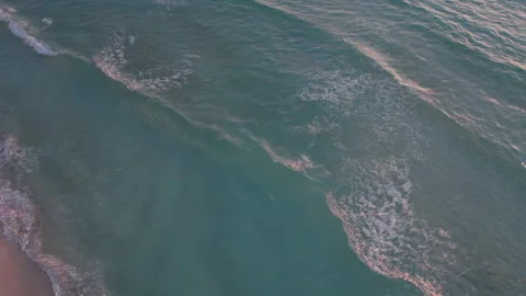 Aerial Top down shot of rolling waves in a crystal clear blue ocean with Stock Footage 250318080