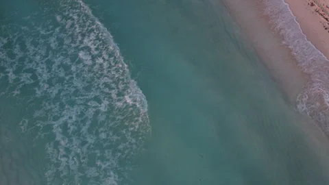 Aerial Top down shot of rolling waves in a crystal clear blue ocean with Stock Footage 250318244