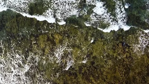 Aerial top down shot of small waves by the shore in Canary Islands, Spain Stock Footage 91575437