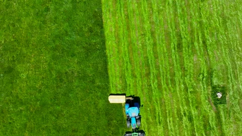Aerial Top Down Shot Of Tractor Mowing Green Grass Field In Poland Video stock 336708809