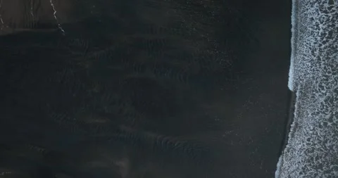 Aerial: Top down shot of Waves breaking on black sand beach Stock-Footage 280668734
