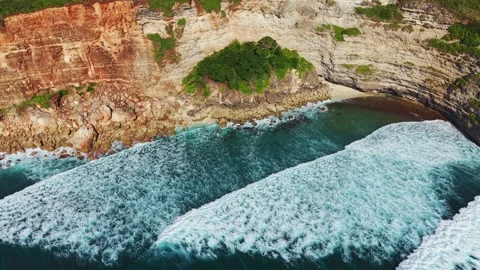 Aerial Top Down Shot of Waves Rolling into Rocky Coastal Cove Stock Footage 340658875