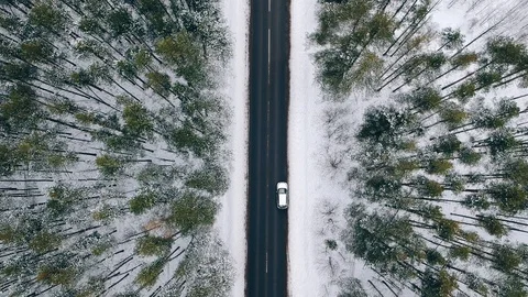 AERIAL, TOP DOWN: silver white car driving down an asphalt road crossing the Stock Footage 129741863