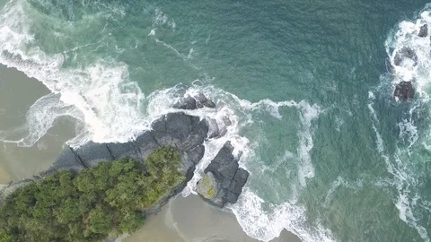 AERIAL Top-down static shot of tropical beach with volcanIC rock formation Stock Footage 119700109