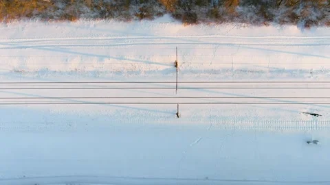 Aerial top-down sunset view of a railroad among pine forests at winter. Stockbeeldmateriaal 302091687