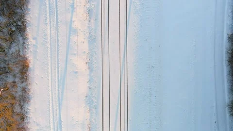 Aerial top-down sunset view of a railroad among pine forests at winter. 스톡 동영상 312299678