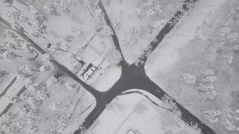 Aerial - Top down tracking shot of blue car drifting on snowy road in forest 動画素材 99836538