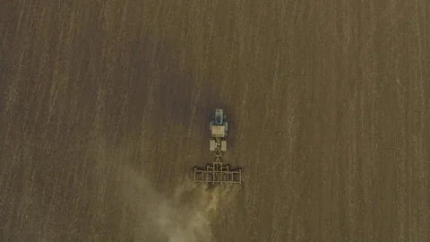 Aerial top down vertical view tractor plows a large field. Dust in shot Stock Footage 118743003