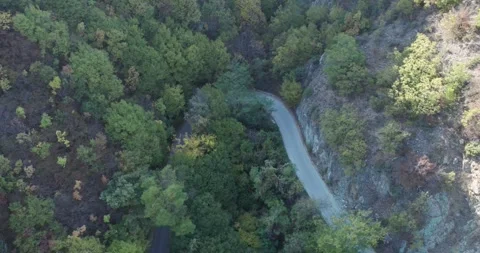 Aerial top down vew of white electric car driving on country road in autumn c Video stock 330100332