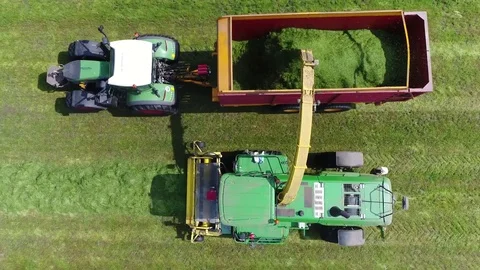 Aerial top down view above tractor and combine harvester unloading grass 4k Stock Footage 75952917