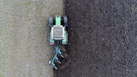 Aerial top-down view above tractor plowing the dark soil 4k Stock Footage 76914932