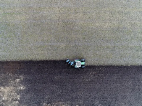 Aerial top-down view above farmland tractor moving from left to right 4k Stock Footage 84590723