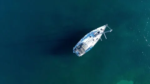 Aerial top down view, a anchored sailboat off the coast of an island Stock Footage 247077080