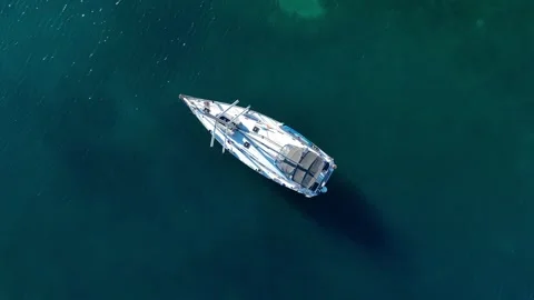 Aerial top down view, a anchored sailboat off the coast of an island Stock Footage 248482851