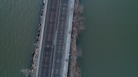 Aerial Top Down View and Tilt Up of Train Tracks Over River Stock Footage 94687904