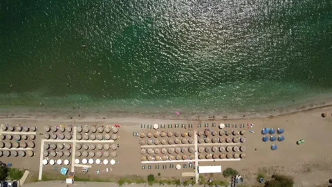 Aerial top down view of beach in Greece with umbrellas and sea shore Stock Footage 246122441