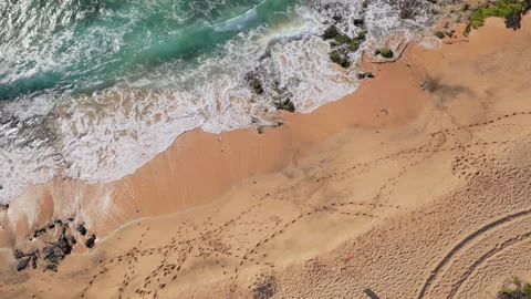 Aerial top down view of a beach with waves crashing onto the shore Stock Footage 332608747
