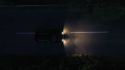 Aerial top down view of black car on the road at night 動画素材 310999620