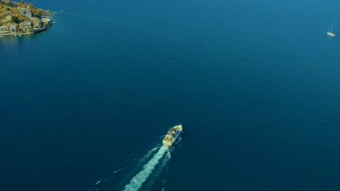 Aerial top down view of boat traveling over ocean of Greece, sun setting over Stock Footage 119323700