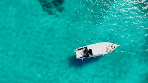 Aerial top down view of boat moving in open sea with clear and turquoise ocean. Stock Footage 131111240