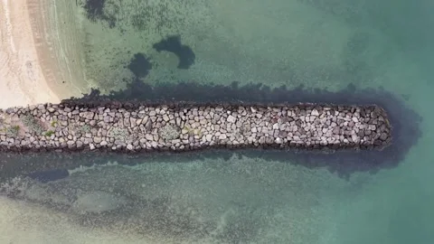 Aerial top down view of a breakwater separating the ocean Video stock 342326447