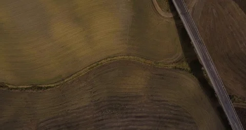 Aerial, top down view on brown plowed fields  and a highway Vídeo Stock 100628570