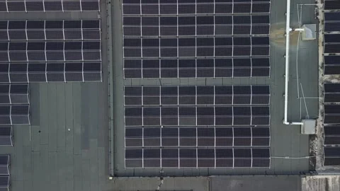 Aerial top down view of building with solar panels on flat roof. Ascending Video stock 269973084