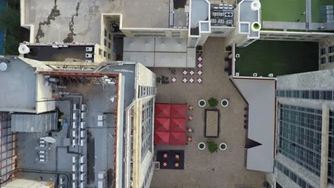Aerial top down view of a building roof and urban courtyard featuring red u.. Vidéo 332388820