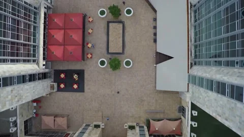 Aerial top down view of a building roof and urban courtyard featuring red u.. Vidéo 332610285