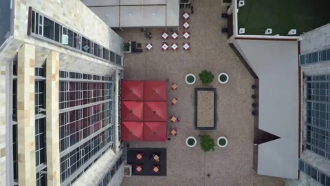 Aerial top down view of a building roof and urban courtyard featuring red u.. Vidéo 332678158