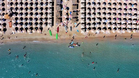Aerial top down view to a busy beach with umbrellas in a row Stock Footage 124263364