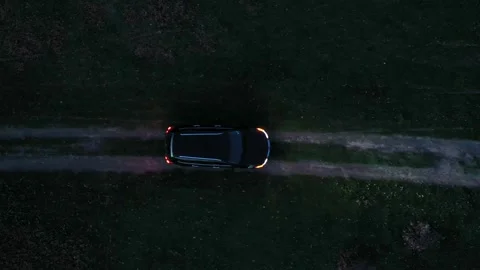 Aerial top down view to a car on emergency lights on dirt road at night 스톡 동영상 321799986