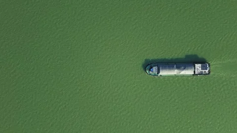 Aerial top down view of a cargo vessel navigates tranquil waters in green river Stock-Footage 310500711