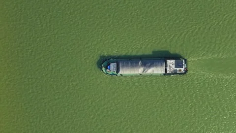 Aerial top down view of a cargo vessel navigates tranquil waters in green river Vídeo Stock 310501570