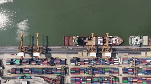 Aerial top down view of cargo ship unloading at container port terminal Video stock 328566652