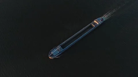 Aerial top down view of cargo ship cruising on dark water Stockbeeldmateriaal 333648874