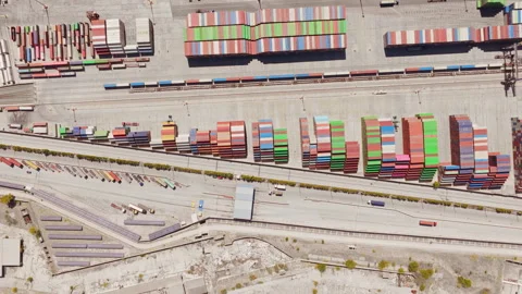 Aerial top down view of a cargo train passing through an industrial port Stock Footage 345006948
