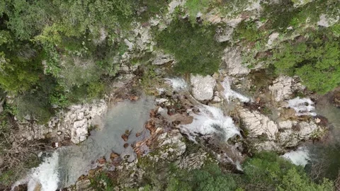 Aerial Top-Down View of cascade rushes down the rocky cliffs near Polylimnio Wat Video stock 303188734