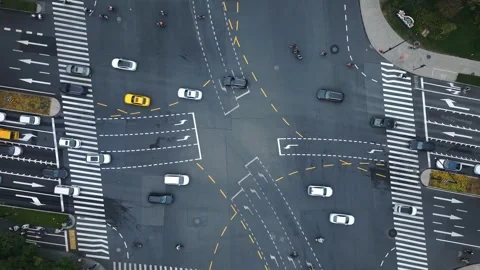 Aerial top down view of city intersection shows traffic movement during daylight Stock Footage 320476583