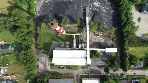 Aerial top-down view of a coal-fired power plant with smokestack and fuel pile 스톡 동영상 347801838